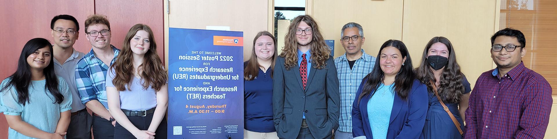 Students and faculty pose for a photo at a research fair.